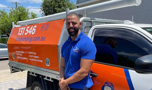 Volkan in front of Jim's Plumbing van